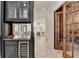 Modern bar area with custom cabinets, wine cooler, and views of kitchen at 4505 Whitestone Way, Suwanee, GA 30024