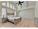 Bright main bedroom features a ceiling fan, hardwood floors, and a large arched window at 4505 Whitestone Way, Suwanee, GA 30024