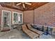 Covered outdoor patio featuring stone floors, a brick wall, wood ceiling, and comfortable lounge chairs at 4505 Whitestone Way, Suwanee, GA 30024