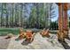 Backyard stone patio with Adirondack chairs and a fire pit, ideal for outdoor gatherings in a private wooded setting at 4505 Whitestone Way, Suwanee, GA 30024