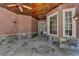 Covered outdoor patio featuring stone floors, a brick wall, wood ceiling, and large windows at 4505 Whitestone Way, Suwanee, GA 30024