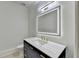 This modern powder room includes a custom mirror, single sink vanity, and sleek fixtures at 4505 Whitestone Way, Suwanee, GA 30024