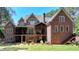 Elegant brick home featuring multi-level balconies and a lush green lawn with mature landscaping at 4505 Whitestone Way, Suwanee, GA 30024