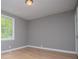 Bright bedroom with hardwood floors, neutral gray walls, and window overlooking the backyard at 8211 Thompson St, Douglasville, GA 30134