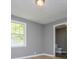 Bedroom boasts natural light from window, gray walls, and wood-look flooring at 8211 Thompson St, Douglasville, GA 30134