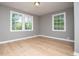 A bright bedroom features hardwood floors, neutral gray walls, and large windows overlooking the backyard at 8211 Thompson St, Douglasville, GA 30134