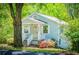 Attractive light blue home with white trim, a welcoming porch, and colorful landscaping with mature trees at 8211 Thompson St, Douglasville, GA 30134