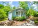 Light blue home with a covered front porch, white railings, and surrounded by lush greenery, offering a peaceful ambiance at 8211 Thompson St, Douglasville, GA 30134