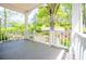 Open front porch with white railings offering a scenic view of the neighborhood and lush green trees at 8211 Thompson St, Douglasville, GA 30134