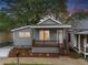 Charming gray home boasts a covered porch, fresh landscaping, and neutral siding at 926 Welch Sw St, Atlanta, GA 30310