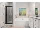 Bright bathroom featuring a soaking tub, granite counters, and tiled shower with black trim at 1195 Awenasa Dr, Villa Rica, GA 30180