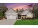 Charming single-story home with a two-car garage, well-manicured lawn, and fresh landscaping at dusk at 1195 Awenasa Dr, Villa Rica, GA 30180