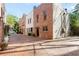 A brick townhouse features a well-maintained paver driveway and lush landscaping at 383 6Th Ne St # 4, Atlanta, GA 30308