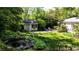 Expansive backyard featuring a pond, lush greenery, garden shed, seating, and trees at 4519 Sims Ct, Tucker, GA 30084