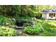 Lush backyard featuring a pond with rocks, a shed, landscaping, and bench seating at 4519 Sims Ct, Tucker, GA 30084