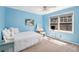 Light blue bedroom features a white bed, plush carpet, and a bright window with natural light at 1935 Northbrooke Ln, Atlanta, GA 30338