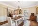 Formal dining room boasts a rustic table, chandelier, hardwood floors and natural light from the window at 1935 Northbrooke Ln, Atlanta, GA 30338