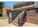 Brick home exterior showcasing a deck, wrought iron railings, and stairs leading to a lower patio at 1935 Northbrooke Ln, Atlanta, GA 30338