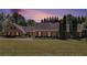 Charming brick home with well-manicured lawn, mature trees, and dusk sky for a warm, inviting feel at 1935 Northbrooke Ln, Atlanta, GA 30338