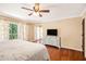Spacious main bedroom offers hardwood floors, backyard access, and a dresser with a television at 1935 Northbrooke Ln, Atlanta, GA 30338