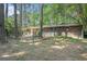Exterior view of a brick home with a fenced-in backyard, and mature trees at 2480 Warwick Ne Cir, Atlanta, GA 30345