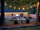 Serene backyard at twilight with string lights, patio furniture, and mature trees at 2574 Warwick Dr, Marietta, GA 30062