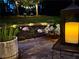 Backyard patio featuring stone and landscaping at night with lights and candle lanterns at 2574 Warwick Dr, Marietta, GA 30062