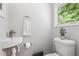 Charming powder room with a pedestal sink, white toilet, and window offering natural light at 2574 Warwick Dr, Marietta, GA 30062