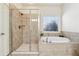 Modern bathroom featuring a glass-enclosed shower and separate soaking tub with tile surround at 4650 Brighton View Trl, Cumming, GA 30040
