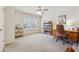 Well-lit bedroom featuring a ceiling fan, window, and desk area perfect for work or study at 4650 Brighton View Trl, Cumming, GA 30040
