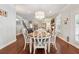 Open dining room with wood floors, plantation shutters, modern chandelier, that flows into living room at 4650 Brighton View Trl, Cumming, GA 30040