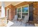 Inviting front porch of brick home featuring stone accents, seating for two, and close proximity to the front door at 4650 Brighton View Trl, Cumming, GA 30040