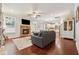 Cozy living room featuring a stone fireplace, hardwood floors, built-in shelving, and large windows for natural light at 4650 Brighton View Trl, Cumming, GA 30040