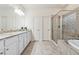 Large bathroom with double vanity, granite counters, soaking tub, and glass enclosed shower at 4650 Brighton View Trl, Cumming, GA 30040