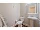 Charming powder room with pedestal sink, decorative mirror, and hardwood floors, offering a touch of elegance at 4650 Brighton View Trl, Cumming, GA 30040