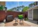 Relaxing patio with a grill, table and chairs, surrounded by a wooden fence and green foliage at 4992 Meadow Ln, Marietta, GA 30068