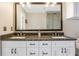 Bathroom vanity with double sinks, stone countertop and large framed mirror with attractive light fixtures at 3235 Roswell Ne Rd # 721, Atlanta, GA 30305