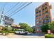 Buckhead Village Lofts, a brick condominium building with trees and parked cars, on a bright sunny day at 3235 Roswell Ne Rd # 721, Atlanta, GA 30305