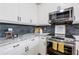 Well-lit kitchen features stainless steel appliances, sleek white cabinetry, and contrasting backsplash at 3235 Roswell Ne Rd # 721, Atlanta, GA 30305