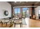 Stylish living room features exposed brick, concrete ceiling, wood floors and balcony access at 3235 Roswell Ne Rd # 721, Atlanta, GA 30305