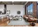 Spacious living room featuring exposed brick, concrete ceilings, and hardwood floors at 3235 Roswell Ne Rd # 721, Atlanta, GA 30305