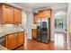 Bright kitchen featuring stainless steel refrigerator, wooden cabinetry, and hardwood floors at 5317 Concordia Se Pl # 10, Mableton, GA 30126