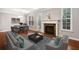 Bright living room featuring a fireplace with a marble surround, hardwood floors, and large windows at 5317 Concordia Se Pl # 10, Mableton, GA 30126