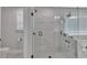 Glass shower featuring marble tiles, built in shelving, and a frosted window at 5382 Pebblebrook Se Ln, Mableton, GA 30126