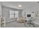Bright bedroom features a comfortable beige beanbag chair, white desk, and natural light at 5382 Pebblebrook Se Ln, Mableton, GA 30126