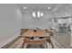 Open dining room features modern lighting, wood table, and access to a bright kitchen at 5382 Pebblebrook Se Ln, Mableton, GA 30126