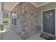 Covered front porch with stone accents, a gray door, and a 'We hope you like Aussies' welcome mat at 5382 Pebblebrook Se Ln, Mableton, GA 30126