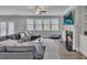Open-concept living room with fireplace, built-ins, large windows, and a ceiling fan at 5382 Pebblebrook Se Ln, Mableton, GA 30126