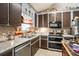 Kitchen showcasing granite counters, dual sinks, stainless steel appliances, and brown cabinets at 126 Amberwood Ln, Euharlee, GA 30145