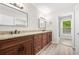 Bathroom featuring double vanity, granite countertop, dark wood cabinetry, modern lighting and mirrors at 3 S Riversong Ln, Alpharetta, GA 30022
